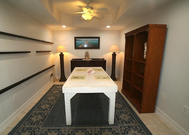 interior space featuring baseboards, a tray ceiling, light tile patterned floors, and recessed lighting