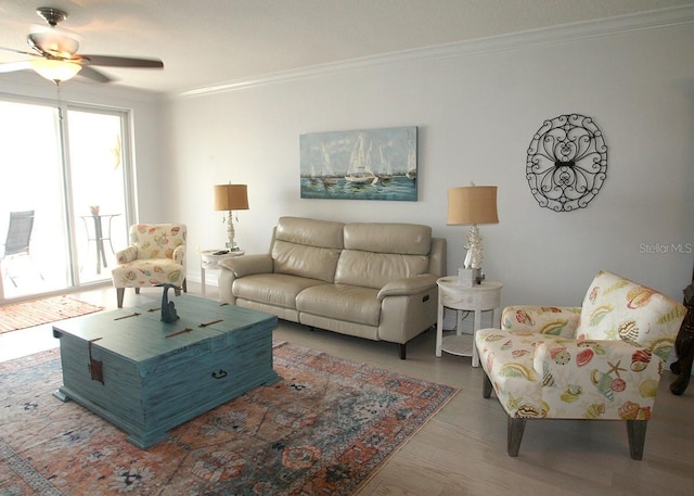 living room with a ceiling fan, crown molding, and wood finished floors