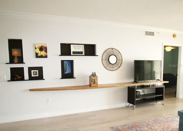 room details with ornamental molding, wood finished floors, visible vents, and baseboards