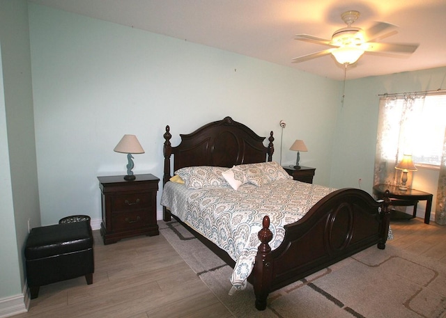 bedroom featuring light wood finished floors and baseboards