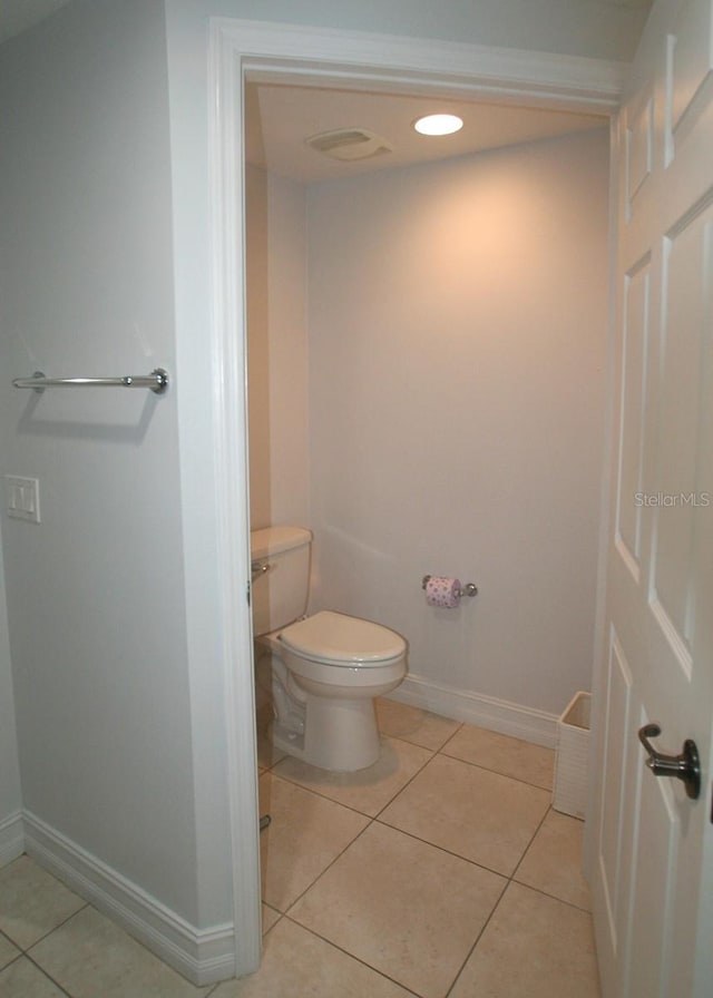 bathroom with toilet, baseboards, and tile patterned floors