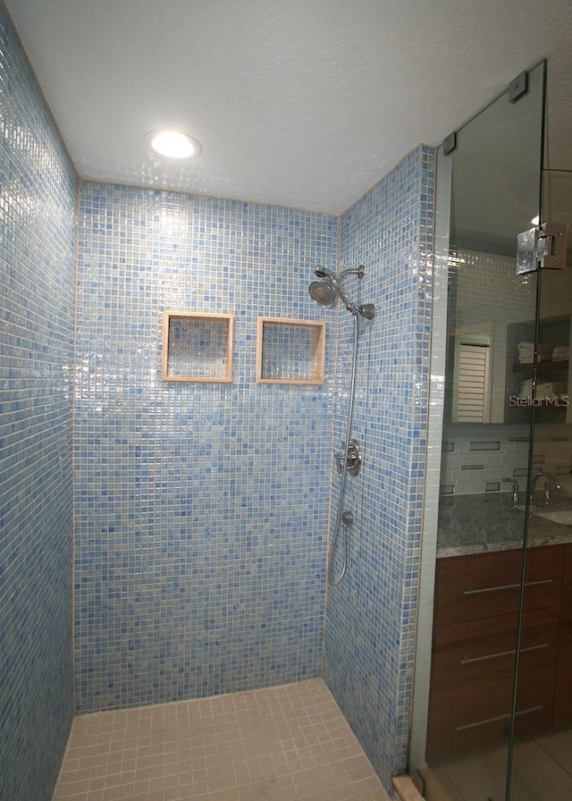 bathroom featuring a stall shower and a sink