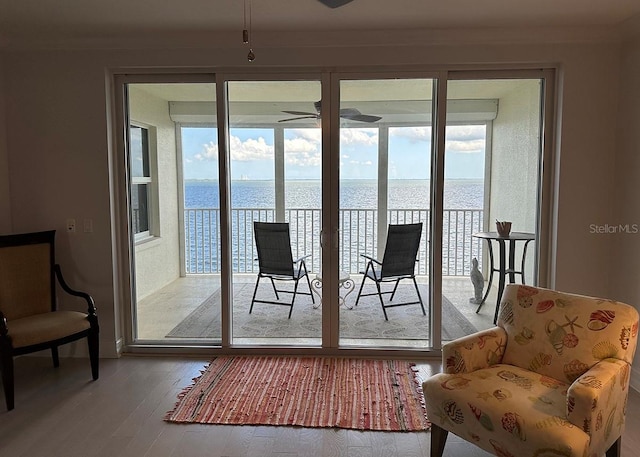 doorway to outside with a water view, a ceiling fan, and wood finished floors