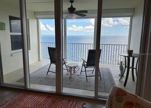 balcony featuring a water view and ceiling fan