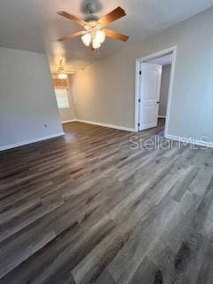 spare room featuring ceiling fan and dark wood-type flooring