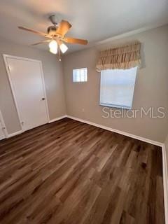 unfurnished bedroom featuring ceiling fan, a closet, and dark hardwood / wood-style flooring