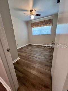 spare room with ceiling fan and dark hardwood / wood-style floors