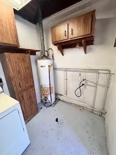 utility room with gas water heater and washer / dryer