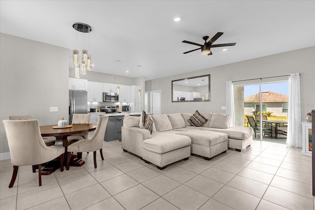 living room featuring ceiling fan with notable chandelier and light tile patterned floors