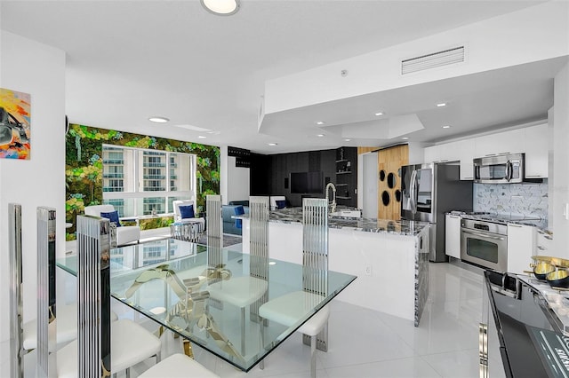 dining area featuring sink and light tile patterned floors