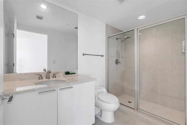 bathroom with vanity, toilet, tile patterned floors, and a shower with shower door