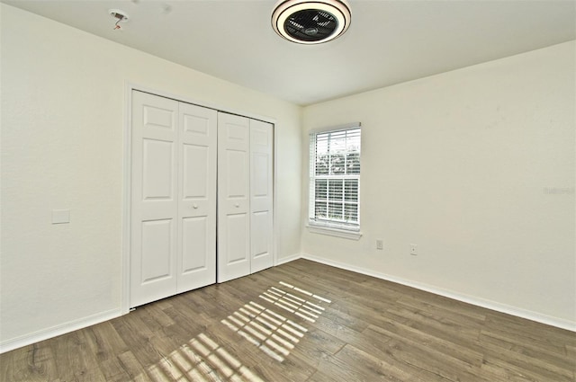 unfurnished bedroom with a closet and hardwood / wood-style flooring