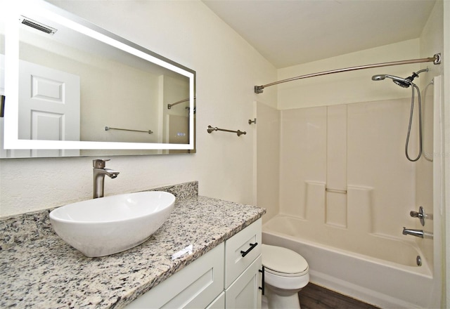 full bathroom featuring hardwood / wood-style floors, vanity, toilet, and shower / tub combination