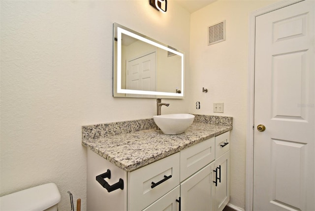 bathroom featuring vanity and toilet