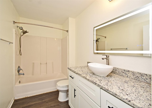 full bathroom with shower / bathing tub combination, vanity, wood-type flooring, and toilet