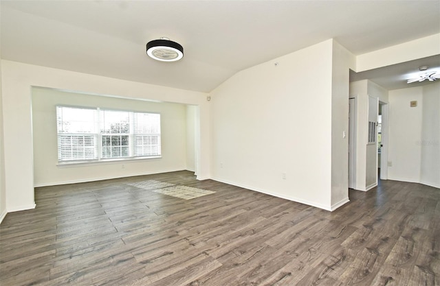 unfurnished room featuring vaulted ceiling and dark hardwood / wood-style floors