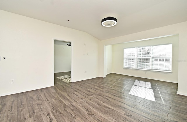 empty room with dark hardwood / wood-style floors and vaulted ceiling