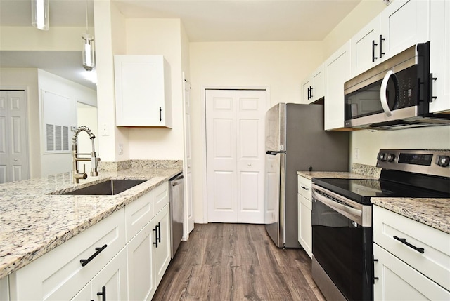 kitchen featuring light stone counters, stainless steel appliances, white cabinetry, and sink