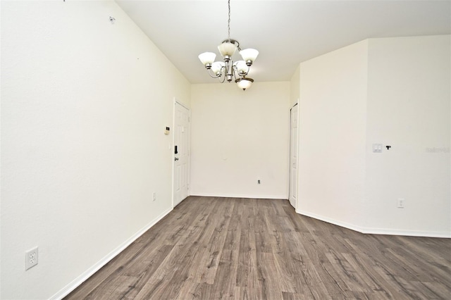 spare room with a chandelier and hardwood / wood-style flooring