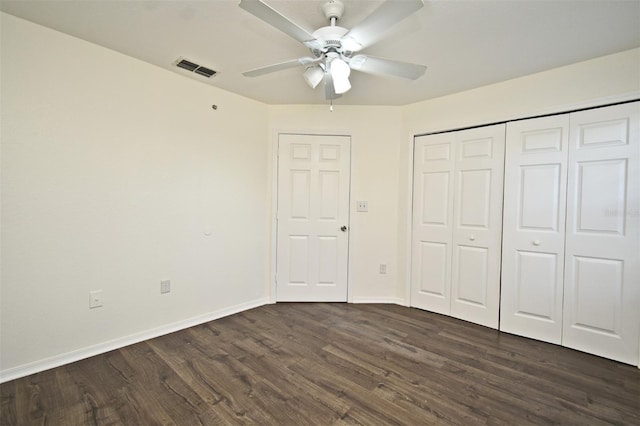 unfurnished bedroom with dark hardwood / wood-style flooring, a closet, and ceiling fan