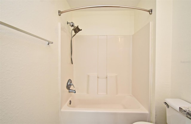 bathroom featuring tub / shower combination and toilet