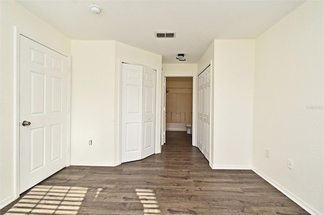 unfurnished bedroom with dark hardwood / wood-style flooring