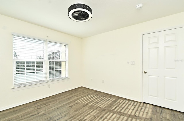 unfurnished room with dark wood-type flooring