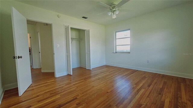 unfurnished bedroom featuring wood-type flooring, a closet, and ceiling fan