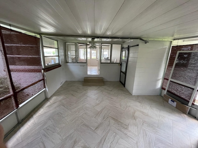 unfurnished sunroom featuring a barn door