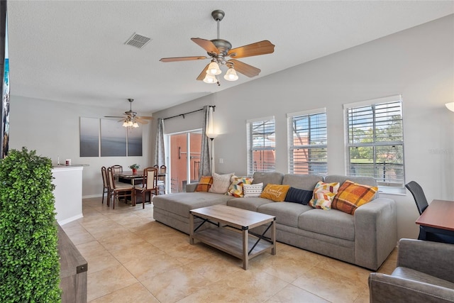 tiled living room with a textured ceiling and ceiling fan