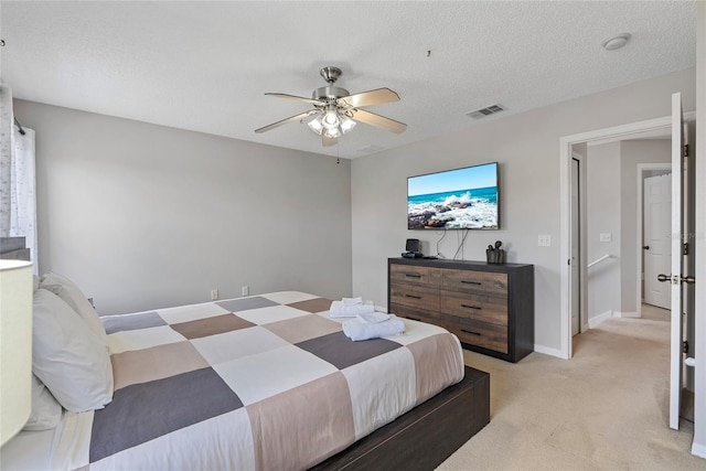 bedroom featuring ceiling fan, light carpet, and a textured ceiling