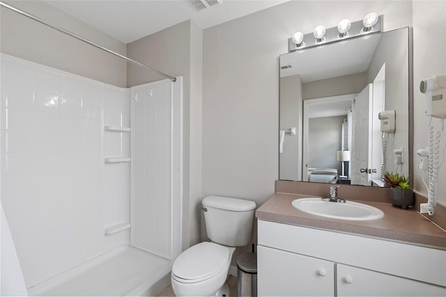 bathroom with a shower, vanity, and toilet