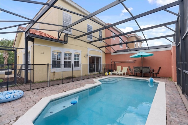 view of pool featuring glass enclosure and a patio