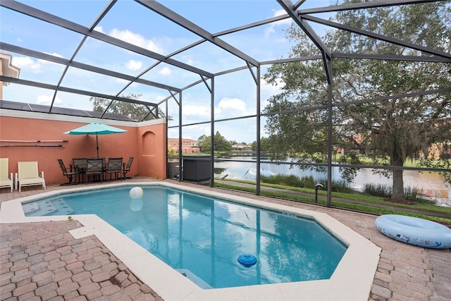 view of swimming pool featuring a patio area, a water view, and glass enclosure