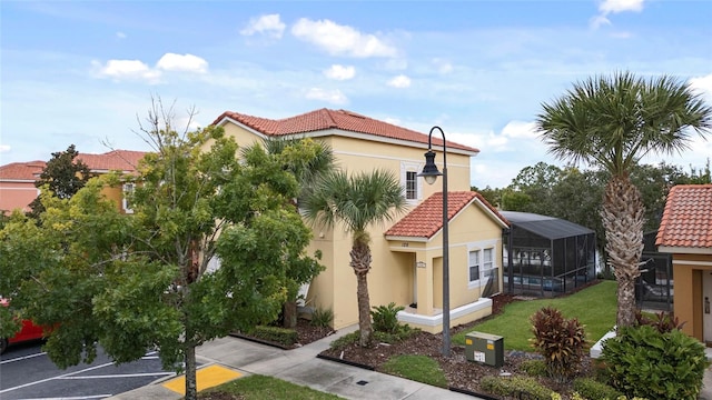 view of side of home featuring a lanai and a lawn