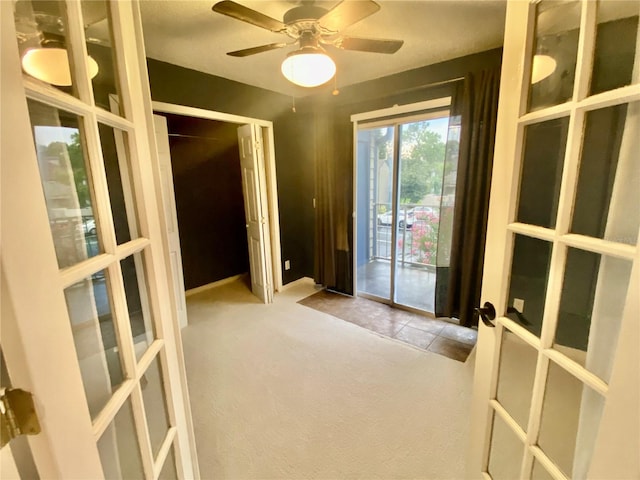 interior space with ceiling fan and light carpet