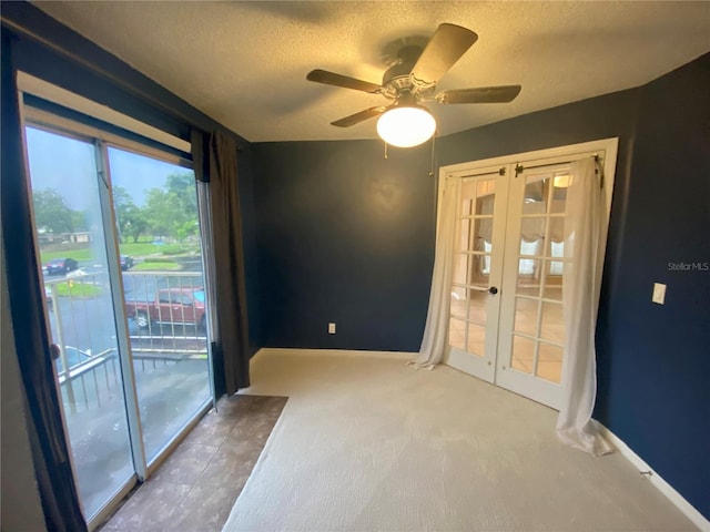 empty room with ceiling fan, carpet floors, a textured ceiling, and french doors