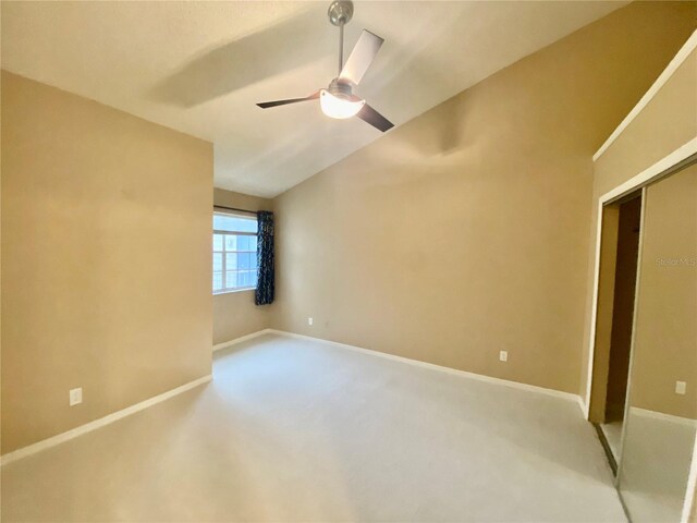 carpeted empty room featuring lofted ceiling and ceiling fan