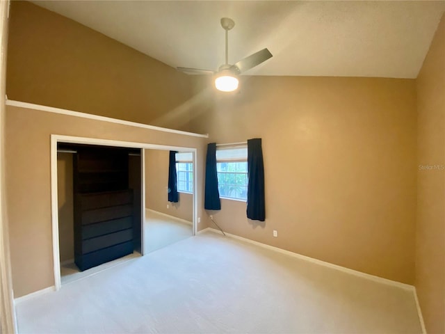 unfurnished bedroom with lofted ceiling, ceiling fan, a closet, and carpet floors