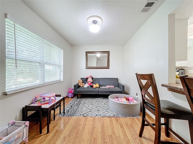 interior space featuring a textured ceiling and light hardwood / wood-style floors