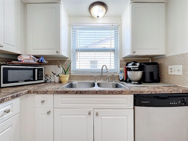 kitchen featuring white cabinets, stainless steel appliances, decorative backsplash, and sink