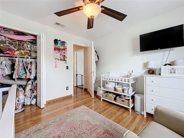 bedroom with a closet, ceiling fan, and light hardwood / wood-style flooring