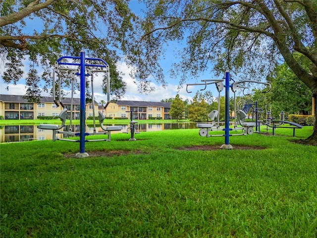 view of play area with a yard and a water view