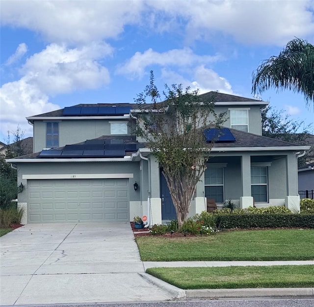 view of front of house featuring a front lawn, a garage, and solar panels