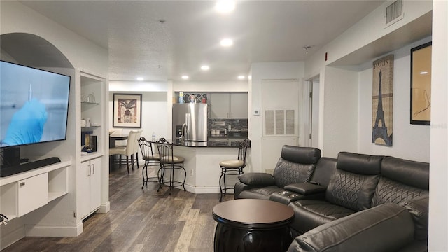 living room with built in features and dark hardwood / wood-style floors