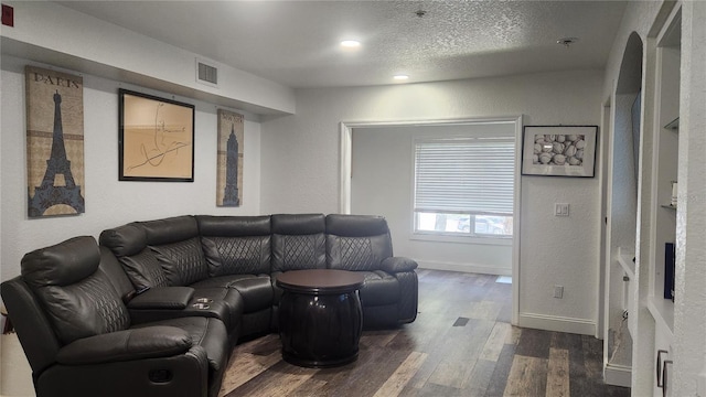 living room featuring dark hardwood / wood-style flooring and a textured ceiling