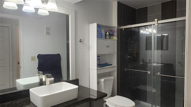 bathroom featuring vanity, toilet, and a shower with shower door