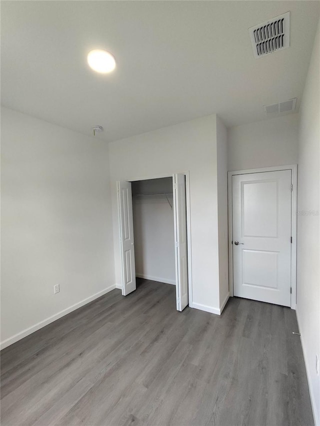 unfurnished bedroom featuring a closet and hardwood / wood-style floors