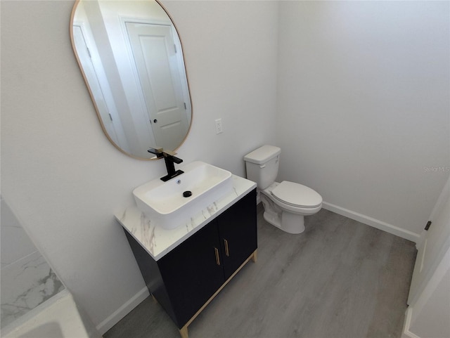 bathroom with vanity, toilet, and wood-type flooring