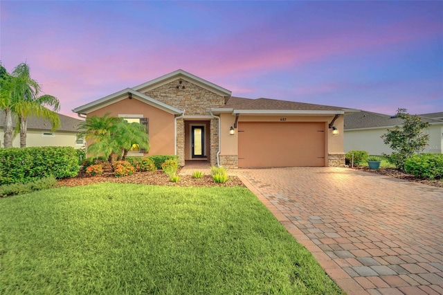 single story home with a garage and a lawn